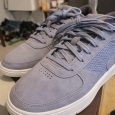 Ett par ljusblå sneakers i mocka på en skokartong.