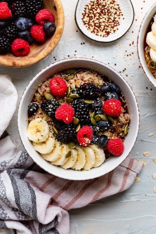 Havregrynsgröt med banan, bär, frön och nötter i en skål