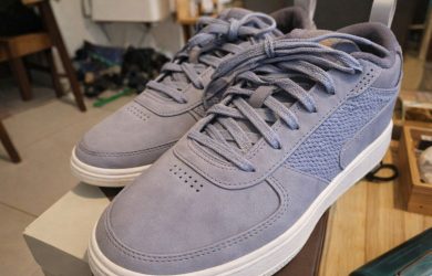 Ett par ljusblå sneakers i mocka på en skokartong.